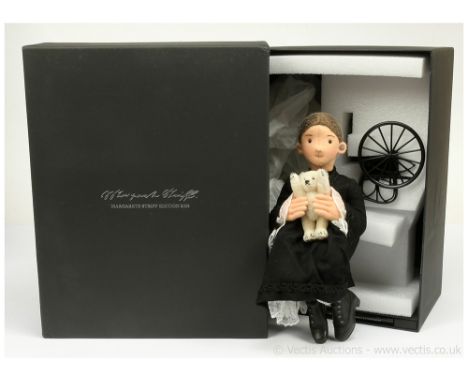 Steiff Margarete felt doll holding a miniature Steiff white mohair teddy bear, black label 421082, LE 750, 2009, seated withi