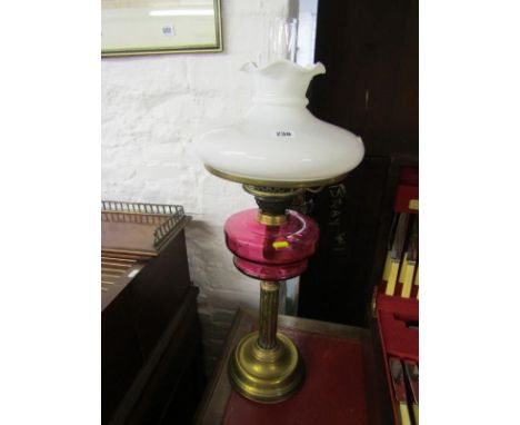 ANTIQUE OIL LAMP, brass column base cranberry glass reservoir oil lamp with milk glass shade 