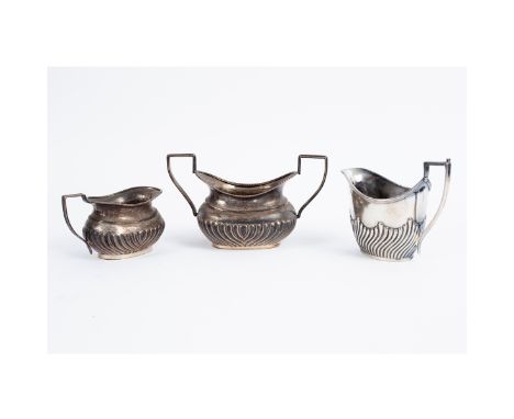 A Victorian bachelor's silver sugar basin and milk jug, Chester 1898/1911, of half ribbed form and a milk jug, Sheffield 1906