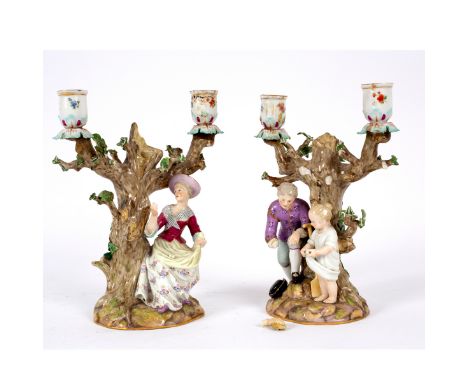 A pair of Meissen porcelain candlestick groups, circa 1900, modelled as children standing before trees, 15cm high/Provenance: