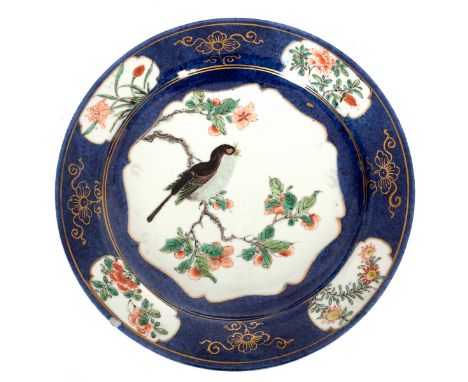 A Chinese powder blue ground famille verte plate, Kangxi, with a central reserve of a sparrow on a fruiting branch, the rim w
