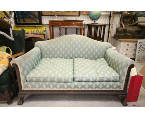 Late 19th / Early 20th century Oak Framed Two Seater Sofa with Shaped Back, the heavily carved frame with front paw feet