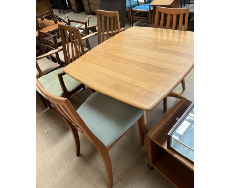 An Ercol dining suite comprising an extending dining table, four chairs and two wall units 