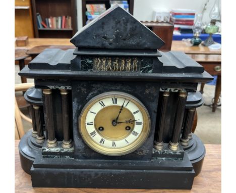 A black slate mantle clock of architectural form, with Roman numerals