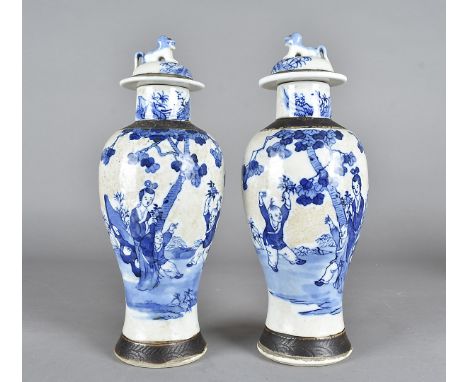 A pair of Chinese blue and white vases, of baulster form with domed covers, having blue and white figural decoration and fami