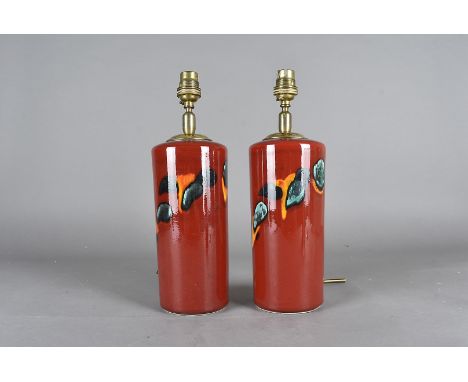 A pair of Poole pottery table lamps, having red ground, with blue, orange and green decoration, 31.5cm high 