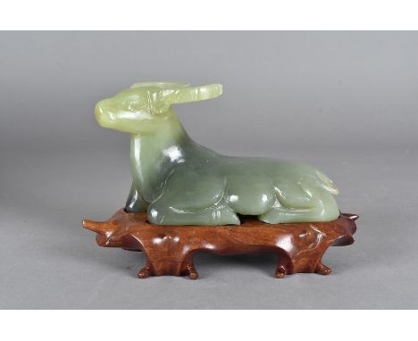 A Jade carving of a water buffalo, modelled reclining on a hardwood stand, in a fitted silk lined box, 16.5 cm long 