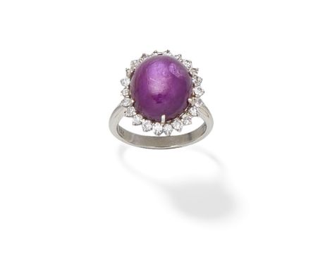 STAR RUBY AND CLUSTER DIAMOND RINGThe oval ruby cabochon within a surround of single-cut diamonds, diamonds approx. 0.40ct to