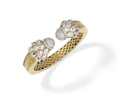 DIAMOND BANGLEThe hinged torque bangle of textured and engraved design, with openwork brilliant-cut diamond terminals, diamon