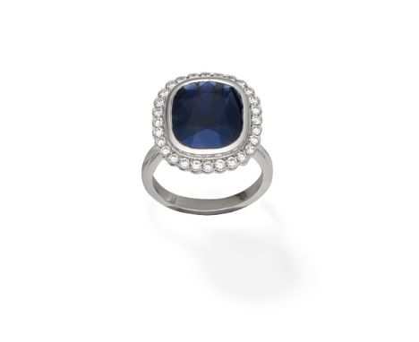 SAPPHIRE AND DIAMOND CLUSTER RINGThe cushion-shaped sapphire within a brilliant-cut diamond surround, mounted in platinum, Lo