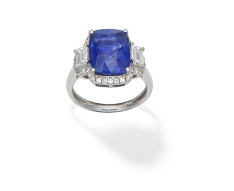 SAPPHIRE AND DIAMOND RINGThe cushion-shaped sapphire, between step-cut diamond shoulders, within a brilliant-cut diamond surr