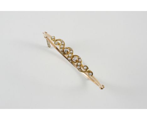 A VICTORIAN DIAMOND AND PEARL HALF HINGED GOLD BANGLE set to one side with two circular-cut diamonds and with half pearls.