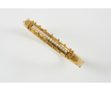 A VICTORIAN GOLD AND PEARL HALF HINGED BANGLE with gold applied decoration to one side and centred with a line of small pearl