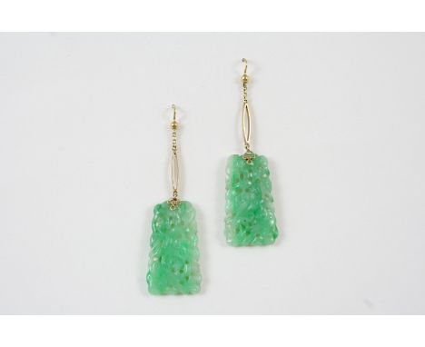 A PAIR OF JADE DROP EARRINGS each set with a section of pierced and carved jade, 5.5cm. long, including gold fitting.