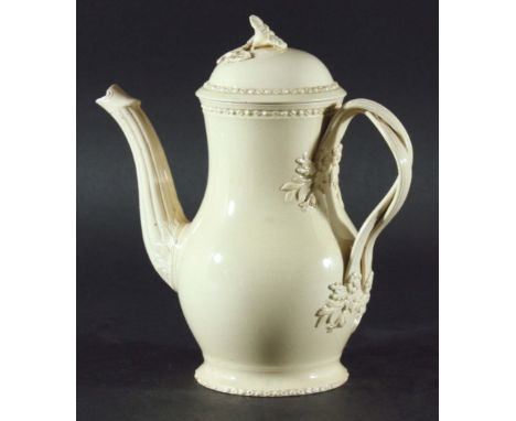 A CREAMWARE COFFEE POT AND COVER late 18th Century, baluster form with twisting handle and flower head finial, 18cm.