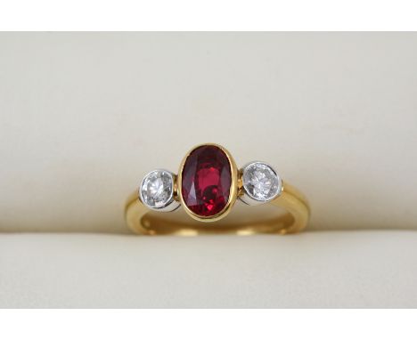 A RUBY AND DIAMOND THREE STONE RING the oval-shaped ruby weighs approximately 1.90 carats and is set with two circular-cut di