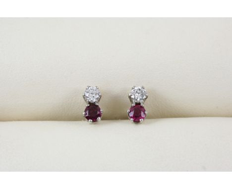 A PAIR OF RUBY AND DIAMOND EARRINGS each set with a circular-cut diamond and ruby, in white gold.