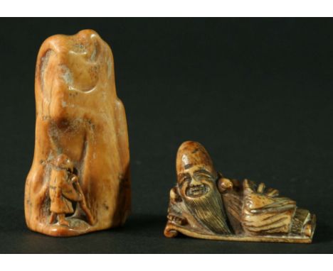 JAPANESE IVORY NETSUKE, carved as an immortal standing before a mountain; together with a bone example of a man reclining on 