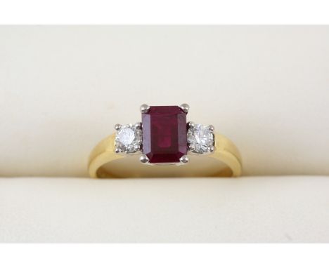 A RUBY AND DIAMOND THREE STONE RING the rectangular-shaped ruby is set with two circular-cut diamonds, in 18ct. gold. Size T.