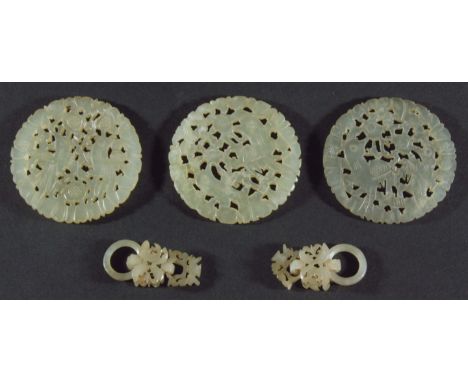 THREE CHINESE JADE TYPE DISCS, pierced with birds in foliage, 5.5cm; together with a pair of similar mounts (5)