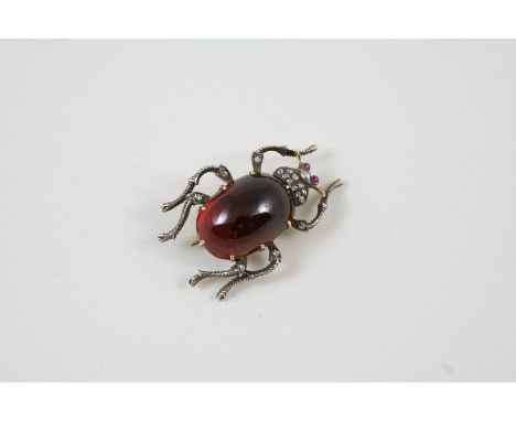A GARNET AND DIAMOND INSECT BROOCH the body set with an oval garnet cabochon and rose-cut diamonds, in gold, with ruby eyes, 