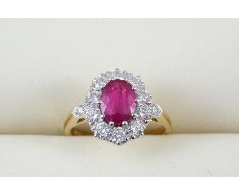 A RUBY AND DIAMOND CLUSTER RING the oval-shaped ruby is set within a surround of circular-cut diamonds, in 18ct. gold. Size N