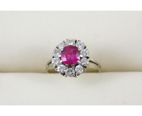 A RUBY AND DIAMOND CLUSTER RING the circular-cut ruby is set within a surround of ten circular-cut diamonds. Size N.