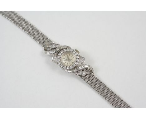A LADY'S DIAMOND AND 18CT. WHITE GOLD WRISTWATCH the circular dial with dagger numerals, with circular-cut diamonds set to th