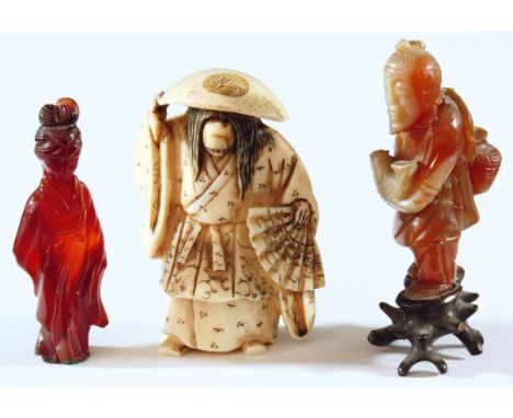JAPANESE BONE NETSUKE, of a person holding a fan, with changing faces; together with two hardstone figural carvings, 6.5cm an