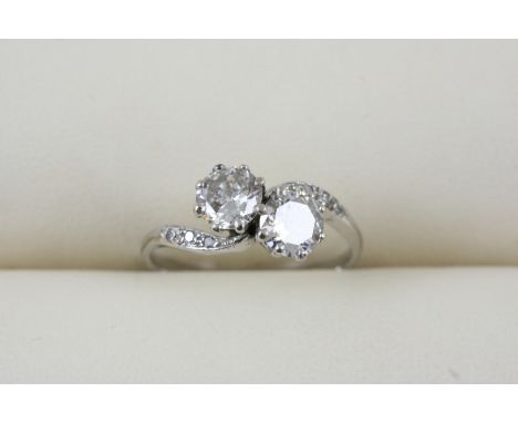 A DIAMOND CROSS-OVER RING the two circular-cut diamonds are set with three small diamonds to each shoulder. Size K.