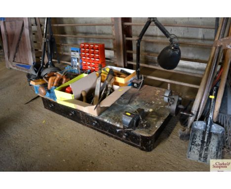 A work top with two drawers and attached Anglepoise style lamp, hand grinder and small vice