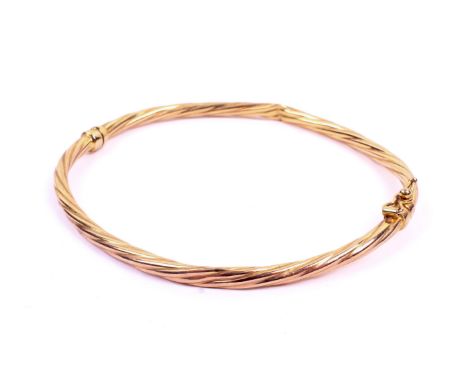 A 9ct gold hinged bangle. Of twist form, with a safety latch, 3.4g