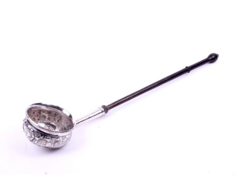 A white metal toddy ladle. Having embossed vine decoration and an etching of a bull, the base constructed of a 1714 Queen Ann