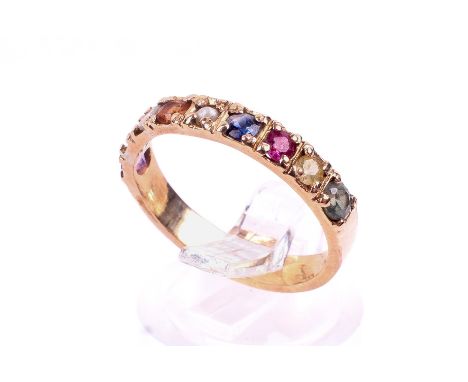 A yellow metal dress ring. Set with eight round faceted stones including a natural sapphire, a natural ruby and a cultured pe