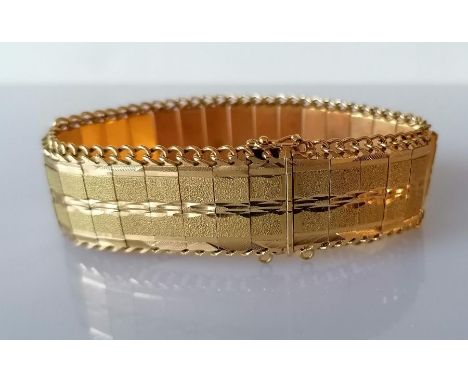 A vintage gold articulated bracelet with textured links and curb-link chain edge, 19 cm, test for 14ct gold, 42.5g, one link 