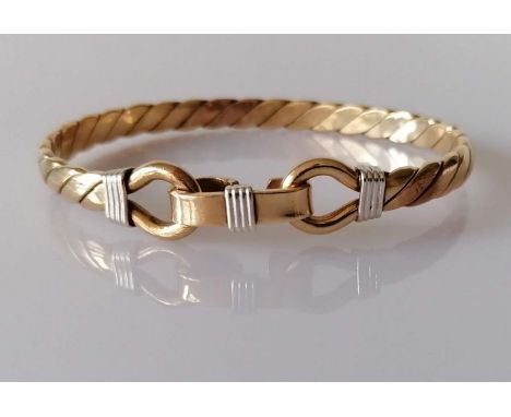 A gold bangle of woven design with clasp, unmarked but tests for 9ct, 37.8g