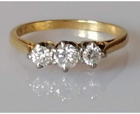 An 18ct yellow gold three-stone diamond ring, central round-cut diamond 0.02 carats, size M, stamped, 2.54g