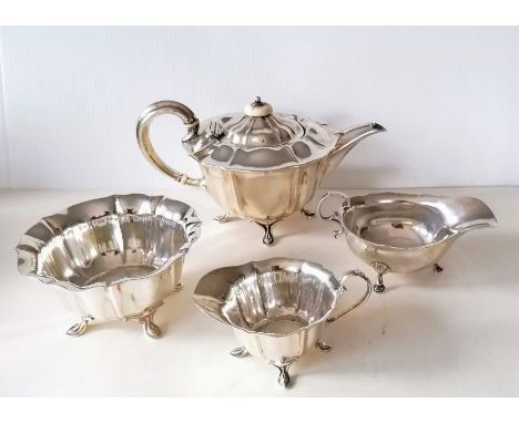 An Edwardian three-piece silver tea service with faceted decoration, each on four hoof feet by Atkin Brothers, Sheffield, 190