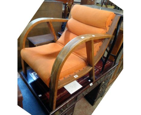 A vintage oak bentwood framed elbow chair with curved back and original studded orange upholstery (faded), set on simple legs