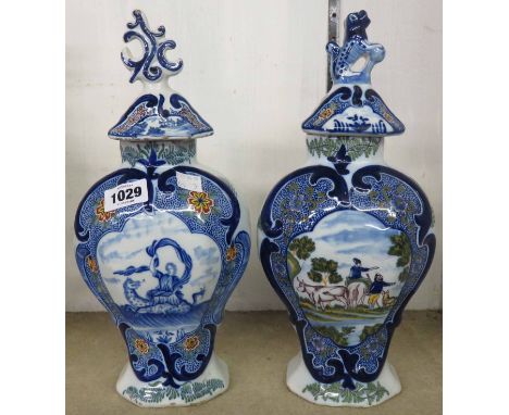 Two similar 19th Century Dutch Delft vases and covers, one with central panel depicting a lady riding a sea serpent, the othe
