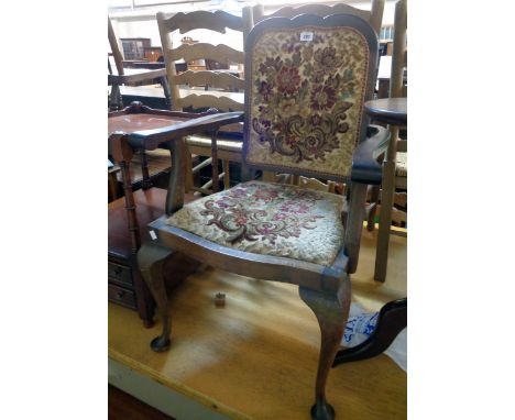 A 20th Century stained walnut framed panel back elbow chair upholstered in floral tapestry, set on cabriole front legs with p
