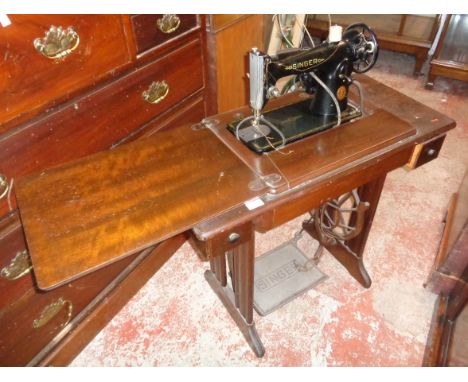 A vintage Singer treadle sewing machine with lamp and peddle