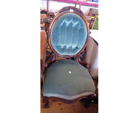 A Victorian carved part show frame drawing room chair with button back upholstery, set on ornate cabriole front legs with bro