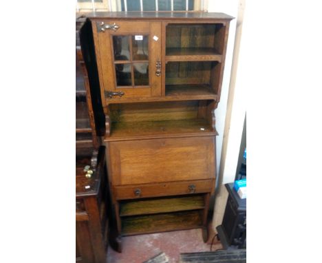 A 31" early 20th Century oak bureau bookcase with Arts &amp; Crafts style decoration to cupboard door and shelf fitted top ov