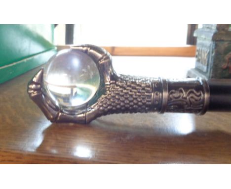 A modern reproduction walking stick with glass ball and metal claw top