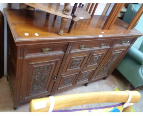 A 5' Edwardian walnut sideboard base with three frieze drawers and carved panel decoration to multiple cupboard doors - a/f