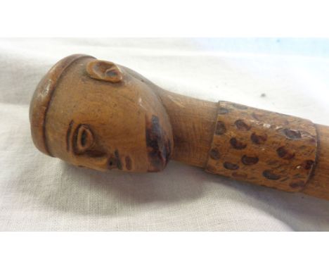 A carved wood walking stick with head pattern knop