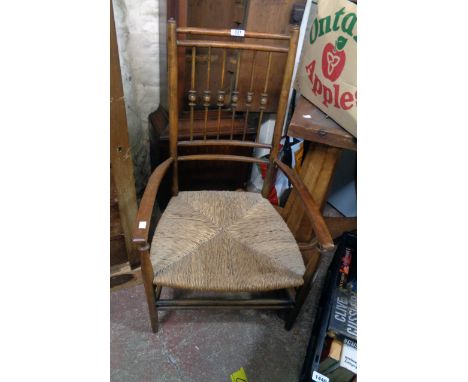 A 19th Century stained beech framed elbow chair with bobbin turned stick back and woven rush seat, set on simple turned suppo