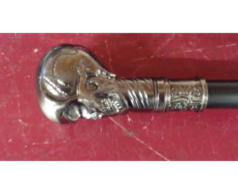 A modern reproduction walking stick with cast metal skull pattern top