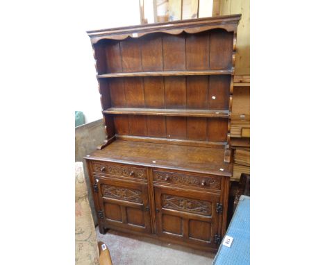 A 4' 20th Century polished oak two part dresser in the antique style with two shelf open plate rack over two frieze drawers a